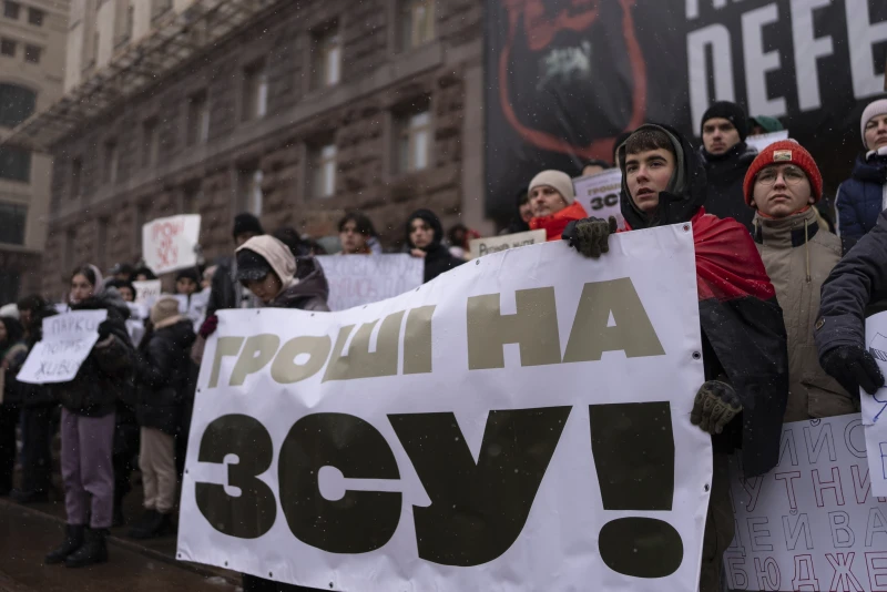 Міша Соболєв, другий справа, тримає банер з написом «Гроші Збройним силам України», центр Києва, Україна, 2 грудня 2023 року